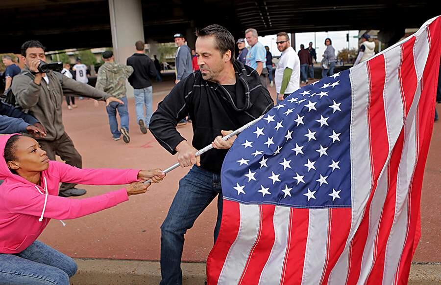 This Oct. 19,. 2014 photo by St. Louis Post Dispatch photographer David Carson shows Ferguson protester Cheyenne Green struggling to hold onto an American flag as a football fan makes a grab for it outside the Edward Jones Dome after a St. Louis Rams game. The photo staff of the St. Louis Post-Dispatch is the winner of the 2015 Pulitzer Prize for Breaking News Photography it was announced Monday, April 15, 2015, at Columbia University in New York. (David Carson, St. Louis Post-Dispatch, Columbia University)