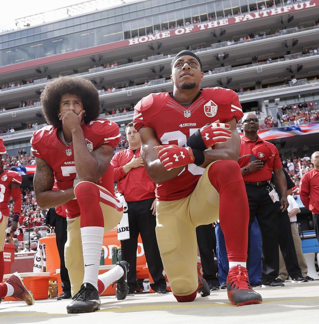FILE - In this Oct. 2, 2016 file photo, San Francisco 49ers quarterback Colin Kaepernick, left, and safety Eric Reid kneel during the national anthem before an NFL football game against the Dallas Cowboys, in Santa Clara, Calif. Colin Kaepernick and Eric Reid have reached settlements on their collusion lawsuits against the NFL, the league said Friday, Feb. 19, 2019.(AP Photo/Marcio Jose Sanchez, File)