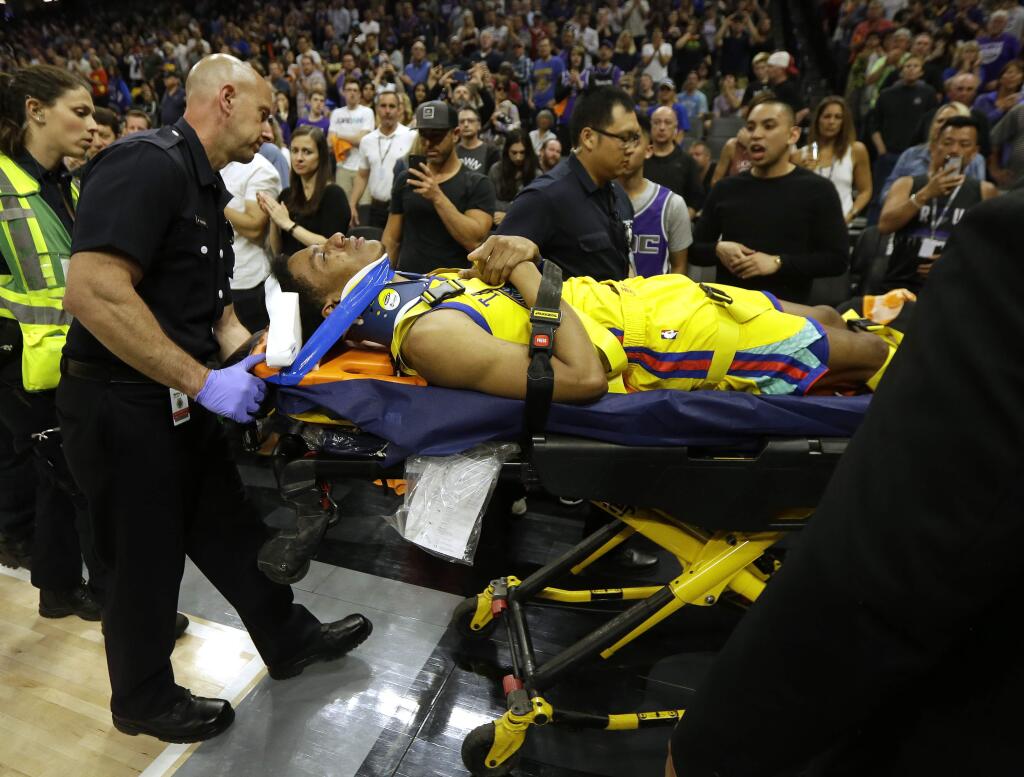 Golden State Warriors guard Patrick McCaw is taken off the court on a stretcher after falling hard to the floor late in the third quarter following a Flagrant 1 foul by the Sacramento Kings' Vince Carter on Saturday, March 31, 2018, in Sacramento. The Warriors won 112-96. (AP Photo/Rich Pedroncelli)