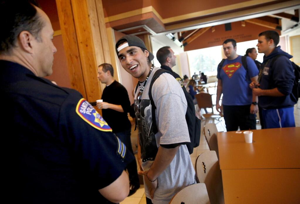 Student Jesus Diaz talks with Santa Rosa Police officer Scott Anderson have an in-depth conversation about the relationship between the Latino and police communities during the 'Coffee with a Cop' event in the Bertolini Student Center on the Santa Rosa Junior College campus in Santa Rosa, on Wednesday, November 18, 2015. (BETH SCHLANKER/ The Press Democrat)