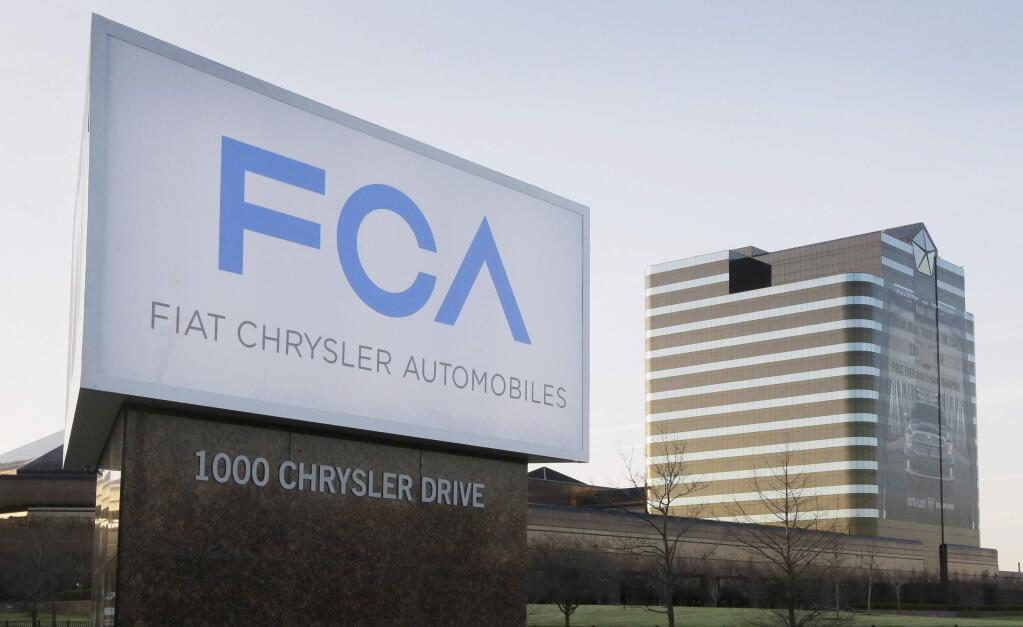 FILE - This Tuesday, May 6, 2014, file photo shows a sign outside Fiat Chrysler Automobiles world headquarters in Auburn Hills, Mich. Fiat Chrysler and Google said Tuesday, April 25, 2017, for the first time will offer rides to the public in the self-driving automobiles they are building under an expanding partnership. (AP Photo/Carlos Osorio, File)