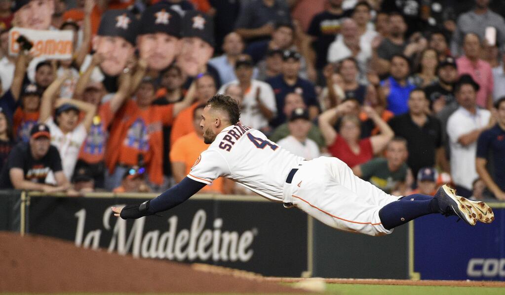 Houston Astros' George Springer dives for third on Alex Bregman's double during the eighth inning of a baseball game against the Oakland Athletics, Tuesday, Aug. 28, 2018, in Houston. Springer was out on the play. (AP Photo/Eric Christian Smith)