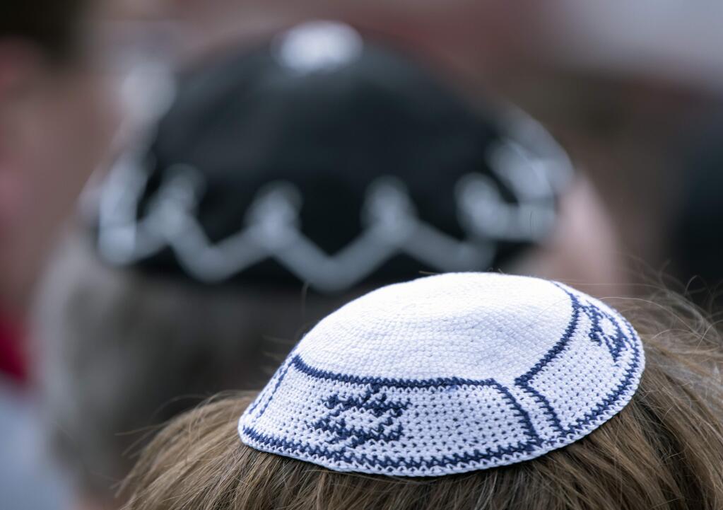 People of different faiths wear the Jewish kippah during a demonstration against antisemitism in Germany in Erfurt, Germany, Wednesday, April 25, 2018. (AP Photo/Jens Meyer)
