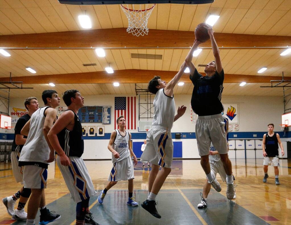 Junior Robbie Leng, right, goes for a shot near the baseline as sophomore Nick DiSanto defends, during practice at Rincon Valley Christian High School in Santa Rosa on Tuesday, Feb. 28, 2017. (Alvin Jornada / The Press Democrat)