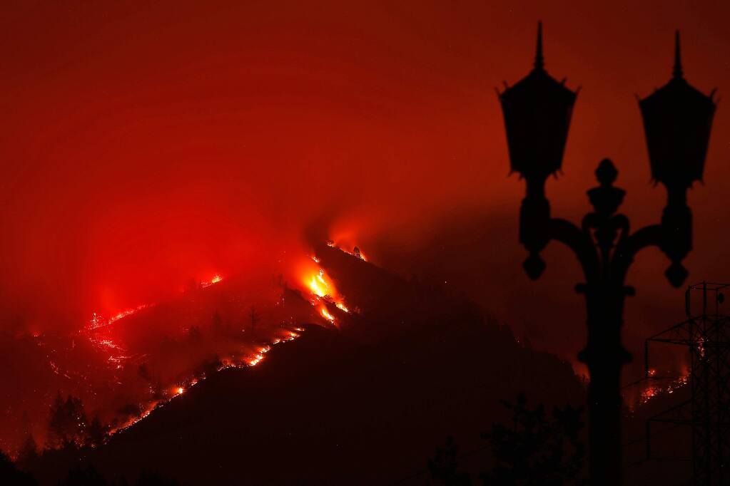 Flames from the Nuns fire are seen at night on a ridgeline adjacent to Ledson Winery in Kenwood, California on Monday, October 16, 2017. (Alvin Jornada / The Press Democrat)