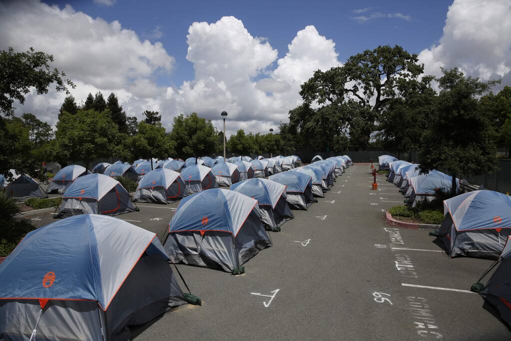 Tents sit readied for homeless residents to arrive at the new temporary homeless camp set up in the parking lot at the Finley Community Center on Monday, May 18, 2020. (BETH SCHLANKER/ The Press Democrat)