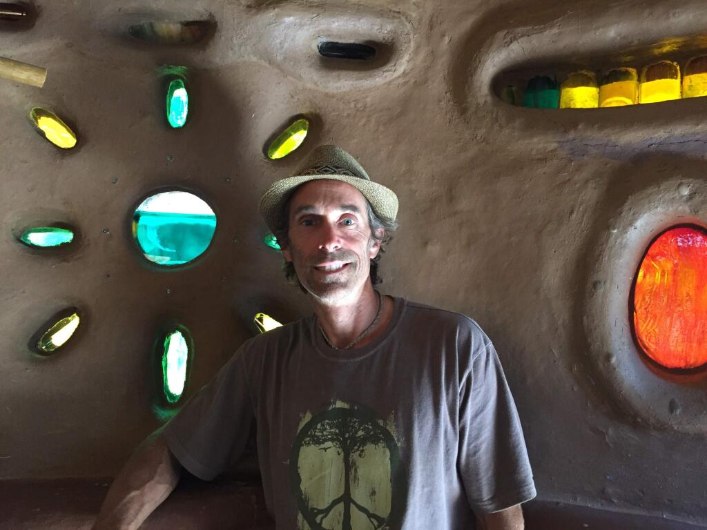 Miguel Elliott (aka Sir Cobalot) inside one of the earthen structures he builds from adobe-based 'cob.'