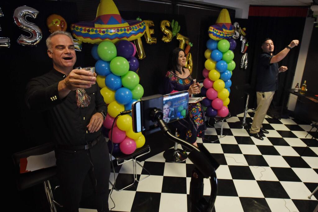 Co-hosts and Latino business leaders from left, Hugo Mata, Mariana Almaraz and Gustavo Sanchez toast with tequila to celebrate Cinco de Mayo during a Facebook Live show called “Power of Knowledge,” in Santa Rosa, Calif., on Tuesday, May 5, 2020. Erik Castro/For The Press Democrat