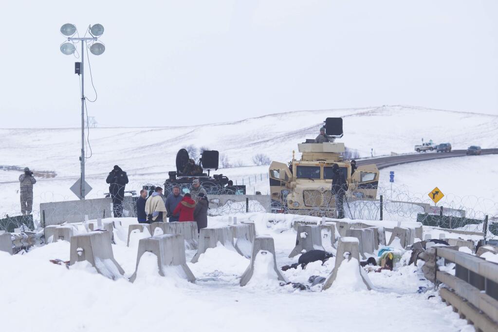 Protesters at the Oceti Sakowin camp speak with law enforcement officers, just outside the Standing Rock Sioux Reservation in Cannon Ball, N.D., Dec. 2, 2016. In the face of orders to evacuate, a sense of defiance is rising at the camp, with structures being erected to survive the harsh Plains winter. Yet there is a feeling that any opportunity to stop the Dakota Access pipeline is fading. (Cassi Alexandra/The New York Times)