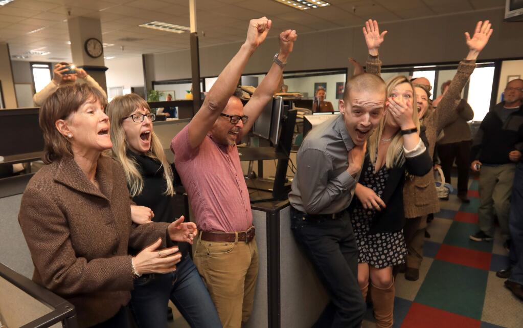 The staff of the Press Democrat including from let, Staff Writers Randi Rossmann, Julie Johnson, Martin Espinoza, J.D. Morris, Christi Warren and Mary Callahan and Photo Editor Chad Surmick react to Monday's Pulitzer Prize announcement. (KENT PORTER / The Press Democrat)