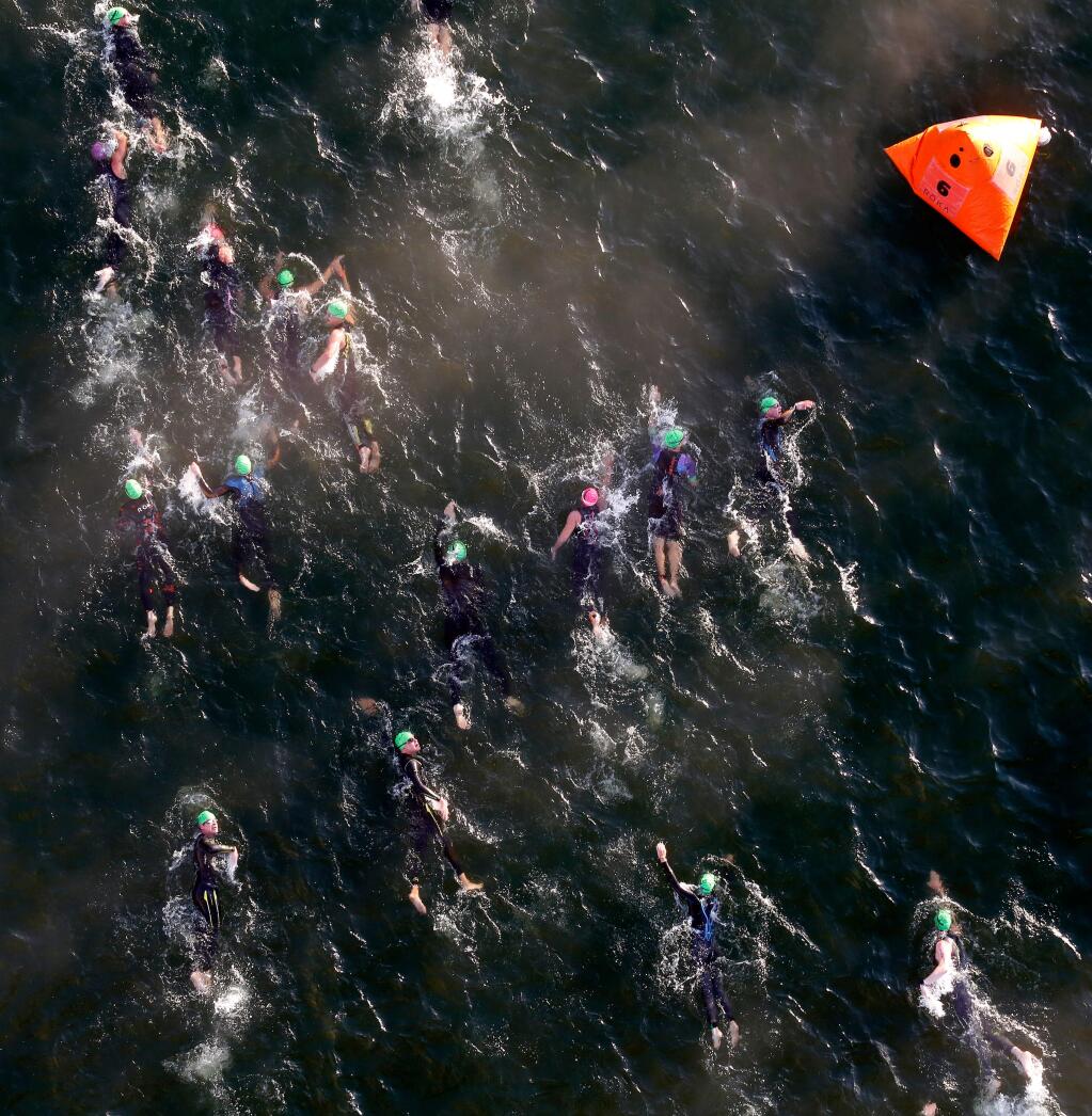 Triathletes swim through the mist of Lake Sonoma as the sun rises during Ironman Santa Rosa, near Geyserville, California, on Saturday, July 29, 2017. (Alvin Jornada / The Press Democrat)