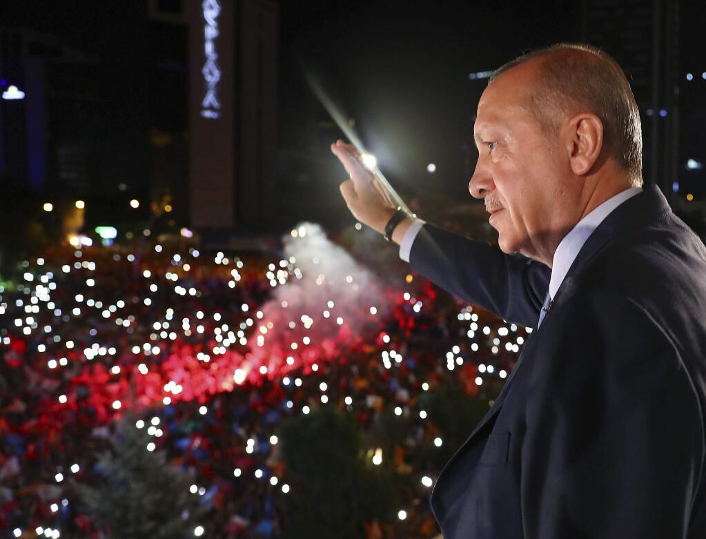Turkey's President Recep Tayyip Erdogan, waves to supporters of his ruling Justice and Development Party (AKP) in Ankara, Turkey, early Monday, June 25, 2018. Erdogan won Turkey's landmark election Sunday, the country's electoral commission said, ushering in a new system granting the president sweeping new powers which critics say will cement what they call a one-man rule (Presidency Press Service via AP, Pool)