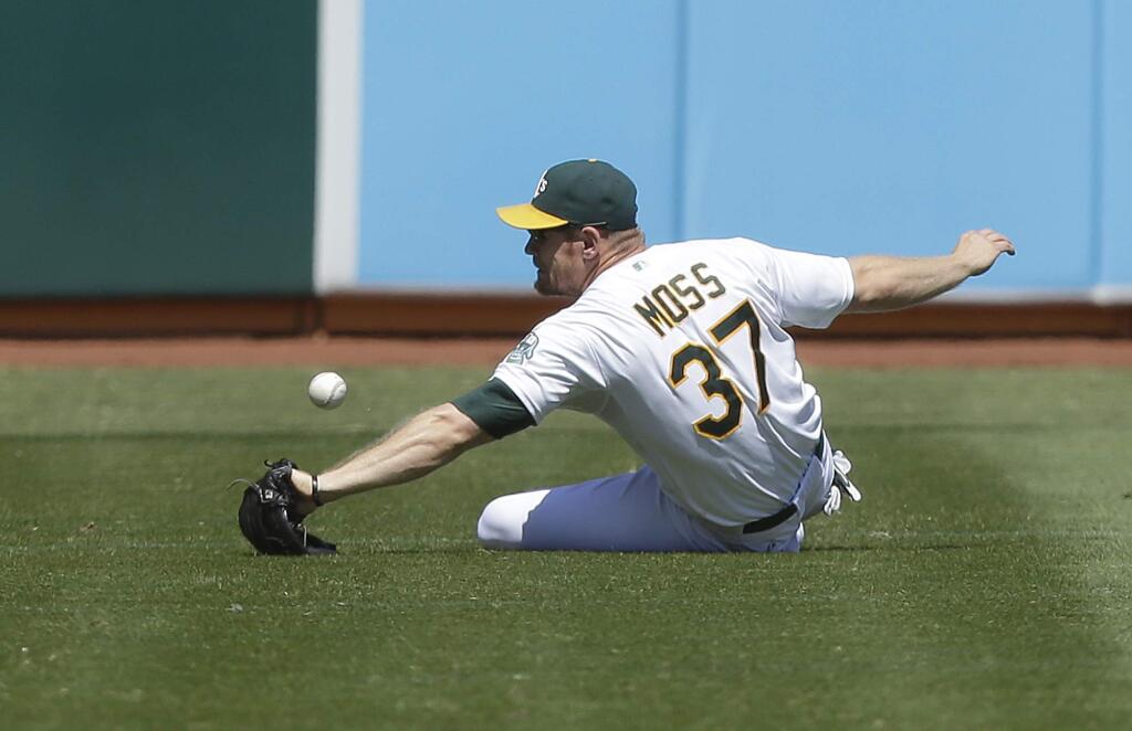 Oakland Athletics left fielder Brandon Moss (37) cannot catch a double hit by Seattle Mariners' Kyle Seager during the fourth inning of a baseball game in Oakland, Calif., Wednesday, Sept. 3, 2014. Moss threw out Seager trying to advance to third base. (AP Photo/Jeff Chiu)