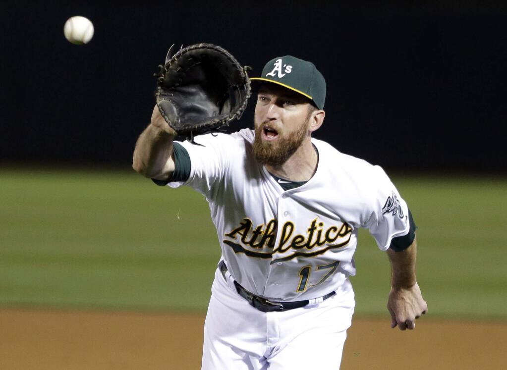 Oakland Athletics first baseman Ike Davis (17) makes a catch on a bunt attempt from Los Angeles Angels' Grant Green during the seventh inning of a baseball game Wednesday, April 29, 2015, in Oakland, Calif. (AP Photo/Marcio Jose Sanchez)