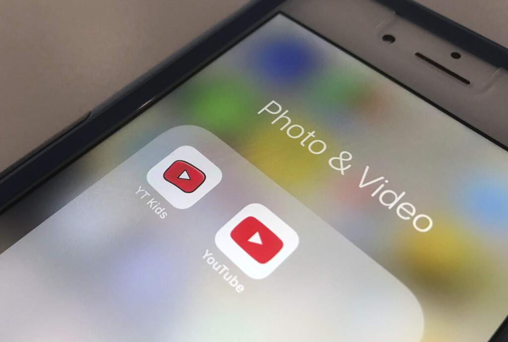 FILE - In this Wednesday, April 25, 2018, file photo, the YouTube app and YouTube Kids app are displayed on a smartphone in New York. A new survey confirms what a lot of parents already know: Teens and tweens are consuming a lot of online video, often on services such as YouTube. (AP Photo/Jenny Kane, File)