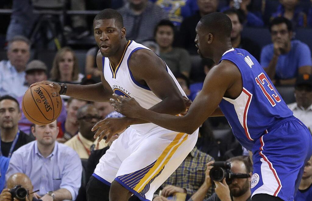 Golden State Warriors' Festus Ezeli, left, drives the ball against Los Angeles Clippers' Ekpe Udoh during the first half of a preseason NBA basketball game Tuesday, Oct. 21, 2014, in Oakland, Calif. (AP Photo/Ben Margot)