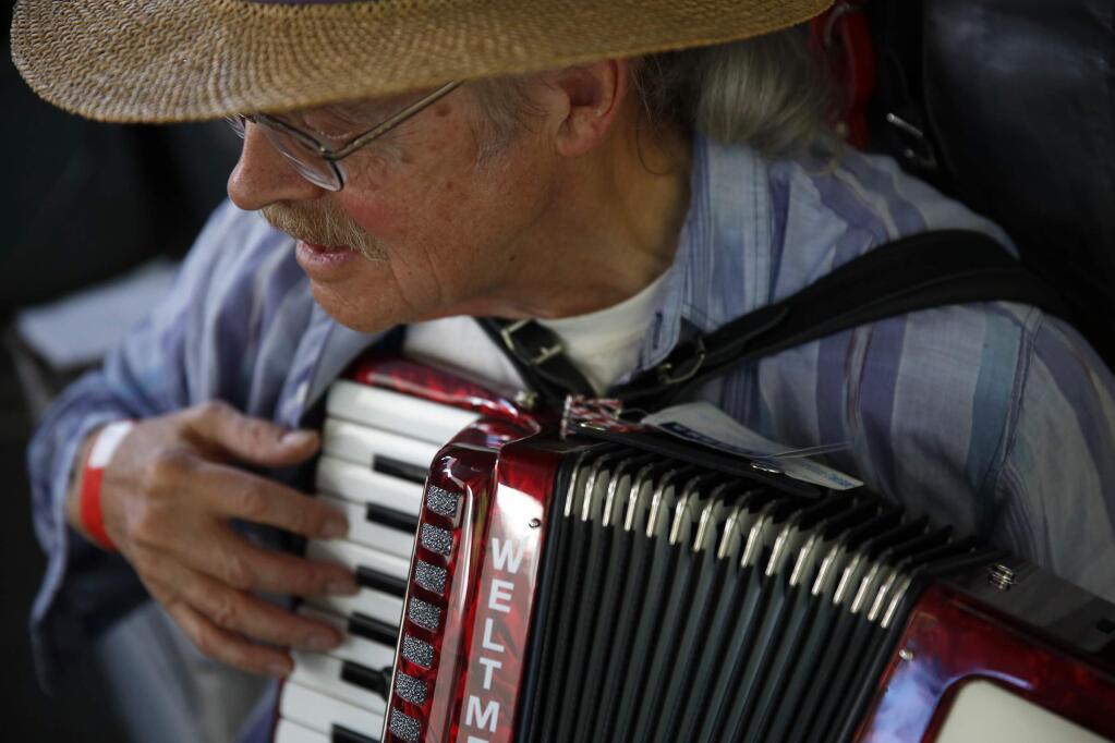 Mike Stagg tries out an accordion for sale during the 24th Annual Cotati Accordion Festival at La Plaza Park on Sunday, August 17, 2014 in Cotati, California. (BETH SCHLANKER/ The Press Democrat)