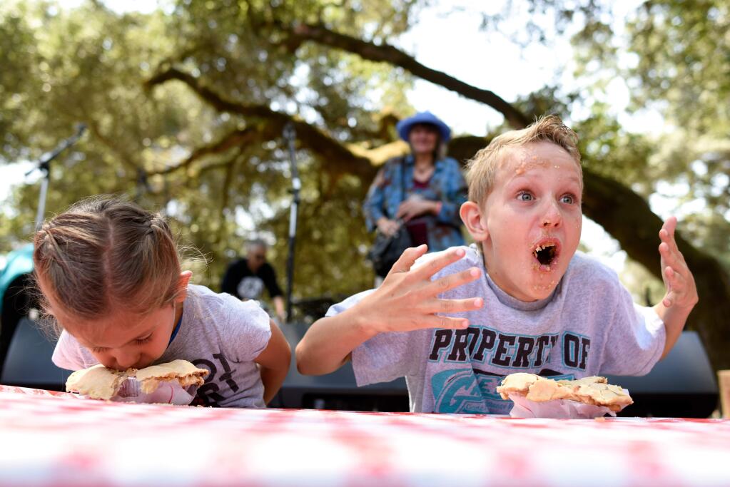 Dylan Gloeckner, age 10, right, reacts to the temperature of his apple pie as he competes in the pie eating contest with his cousin Olivia Padron, age 3, left, at the Gravenstein Apple Fair in Sebastopol, California, on August 8, 2015.