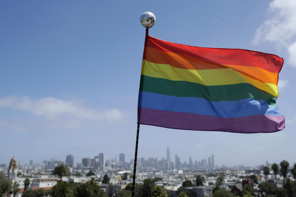 FILE- A rainbow flag flutters in the breeze at Dolores Park in San Francisco in this 2020 photo. A group of about 10 Windsor High School students protested an Oct. 11 National Coming Out Day event on campus, in which students were encouraged to wear rainbow colors in support of the LGBTQ community. Protesters, instead, wore red, white and blue clothing and clothes emblazoned with versions of the “Don’t Tread on Me” Gadsden flag. (AP Photo/Jeff Chiu)