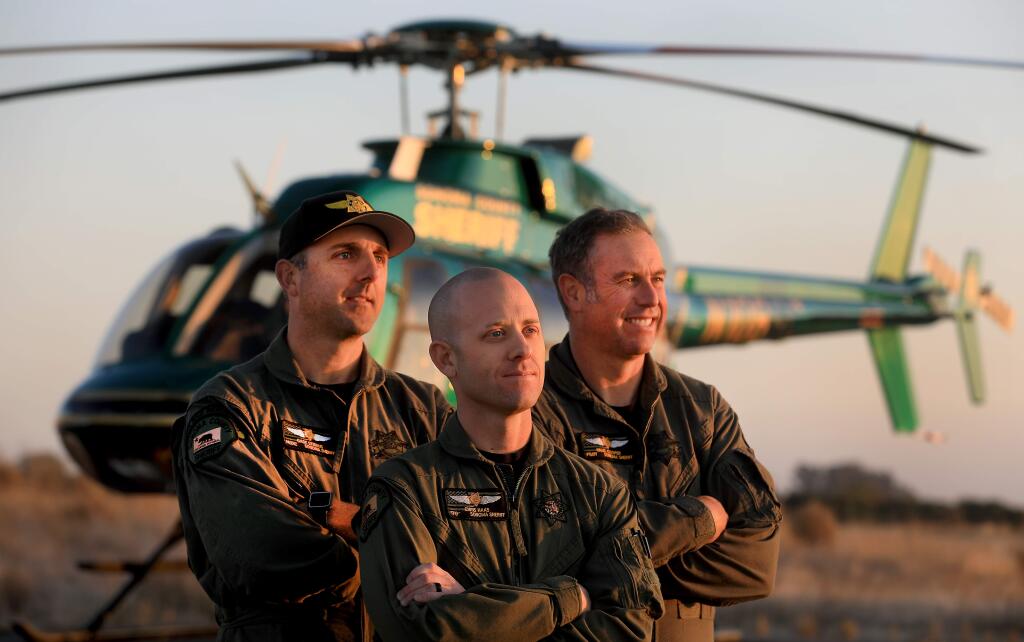 From left, medic Gabe Stirnus, tactical flight officer Chris Haas and pilot Nigel Cooper, of the Sonoma County Sheriff's Department Henry 1 flight crew, were on duty the night that the Kincade fire broke out. Photo taken Friday, Nov. 22, 2019. (Kent Porter / The Press Democrat)