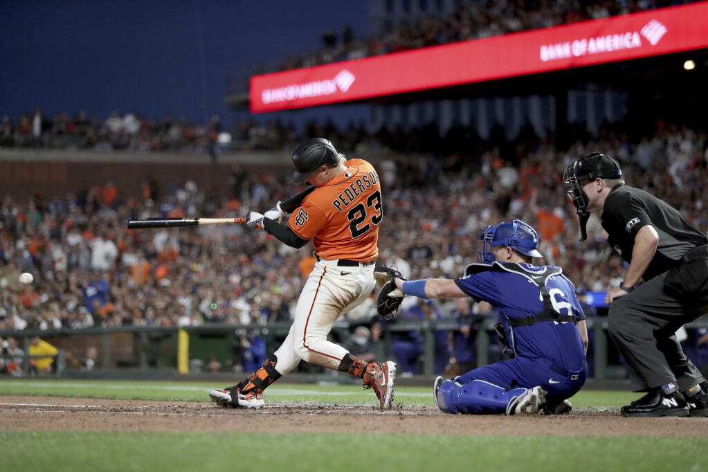 The Giants’ Joc Pederson hits a two-run single in front of Los Angeles Dodgers catcher Will Smith during the fifth inning in San Francisco, Friday, June 10, 2022. (AP Photo/Jed Jacobsohn)