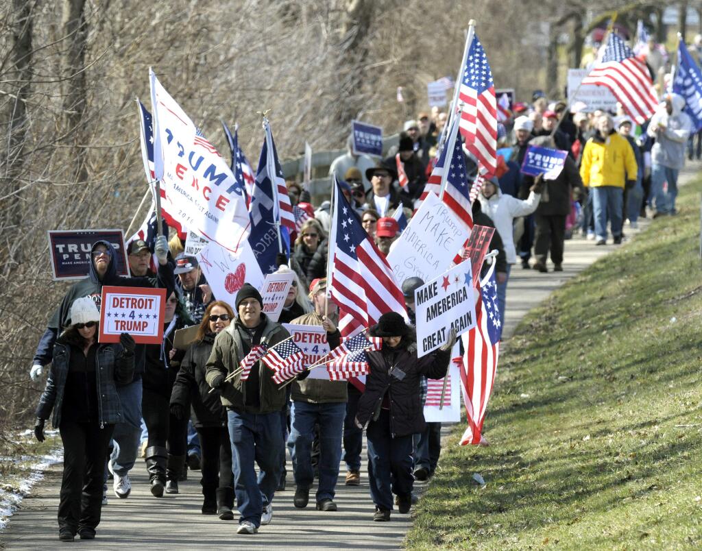 Donald Trump supporters march in Clinton Township, Mich. on March 4. (TODD McINTURF / Detroit News)