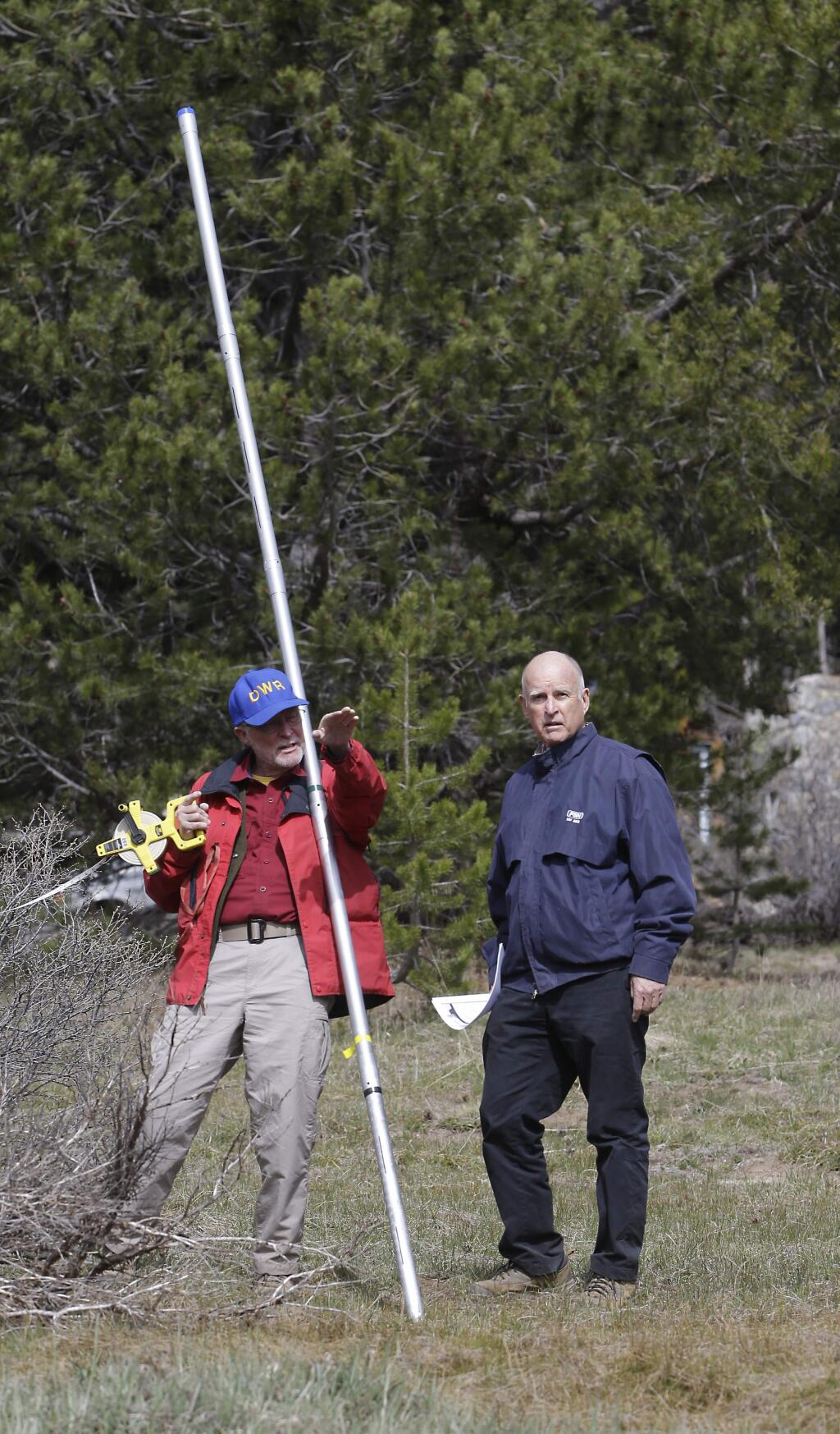Frank Gehrke, chief of the California Cooperative Snow Surveys Program for the Department of Water Resources, explains to Gov. Jerry Brown how he normally conducts a snow survey, near Echo Summit, Calif., Wednesday, April 1, 2015. Gehrke said this was the first time since he has been conducting the survey that he found no snow at this location at this time of the year. Brown announced that he signed an executive order requiring the state water board to implement measures in cities and towns to cut water usage by 25 percent compared with 2013 levels. (AP Photo/Rich Pedroncelli)