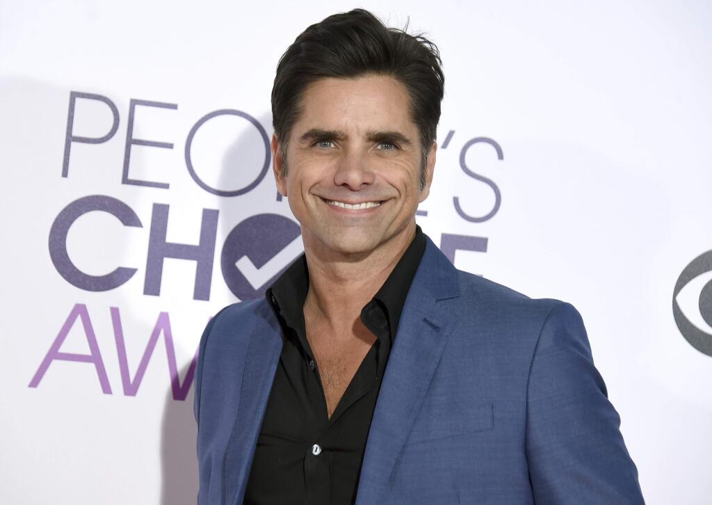 FILE - In this Jan. 18, 2017 file photo, John Stamos arrives at the People's Choice Awards at the Microsoft Theater in Los Angeles. Stamos announced his engagement to actress Caitlin McHugh on social media Oct. 22, 2017. (Photo by Jordan Strauss/Invision/AP, File)