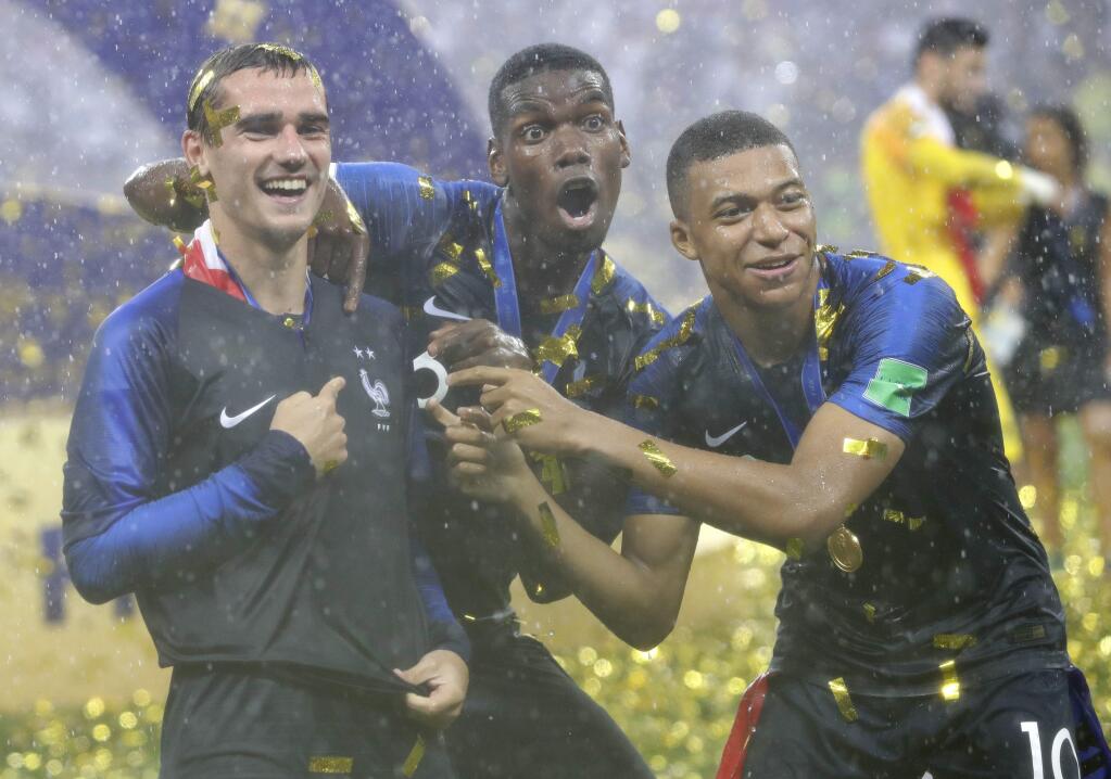 France's Antoine Griezmann, points to two stars on his jersey indicating two world cup wins, as he celebrates with Paul Pogba and Kylian Mbappe after the final match between France and Croatia at the 2018 soccer World Cup in the Luzhniki Stadium in Moscow, Russia, Sunday, July 15, 2018. France won the final 4-2. (AP Photo/Matthias Schrader)