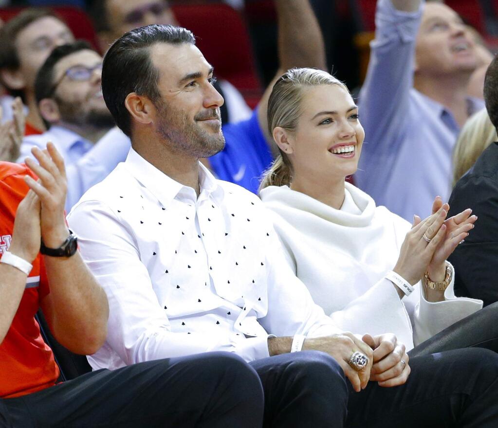 FILE - In this April 5, 2018, file photo, Houston Astros pitcher Justin Verlander and his wife, model Kate Upton attend an NBA basketball game between the Portland Trail Blazers and the Houston Rockets in Houston. Upton and Verlander are expecting their first child. Upton announced the pregnancy on Instagram on Saturday, July 14, 2018, in a post with the hashtag 'pregnant in Miami' where she tagged Verlander. (AP Photo/Michael Wyke, File)