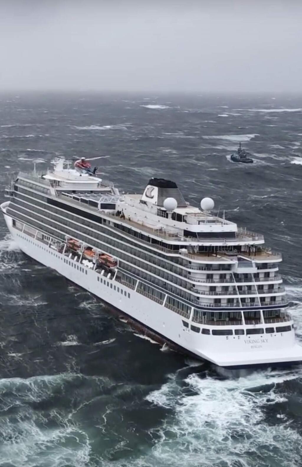 In this image taken from video made available by CHC helicopters, helicopters fly over the cruise ship Viking Sky after it sent out a Mayday signal because of engine failure in windy conditions off the west coast of Norway, Saturday March 23, 2019. A cruise ship with engine problems sent a mayday call off Norway's western coast on Saturday, then began evacuating its 1,300 passengers and crew amid stormy seas and heavy winds in a high-risk helicopter rescue operation. (CHC helicopters via AP)