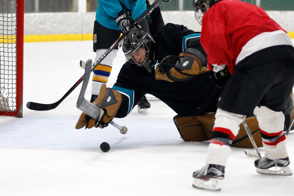 Goalie Nate Panek dives onto the puck to protect his goal during a pickup hockey game at Snoopy's Home Ice in Santa Rosa, California, on Wednesday, June 21, 2017. (Alvin Jornada / The Press Democrat)