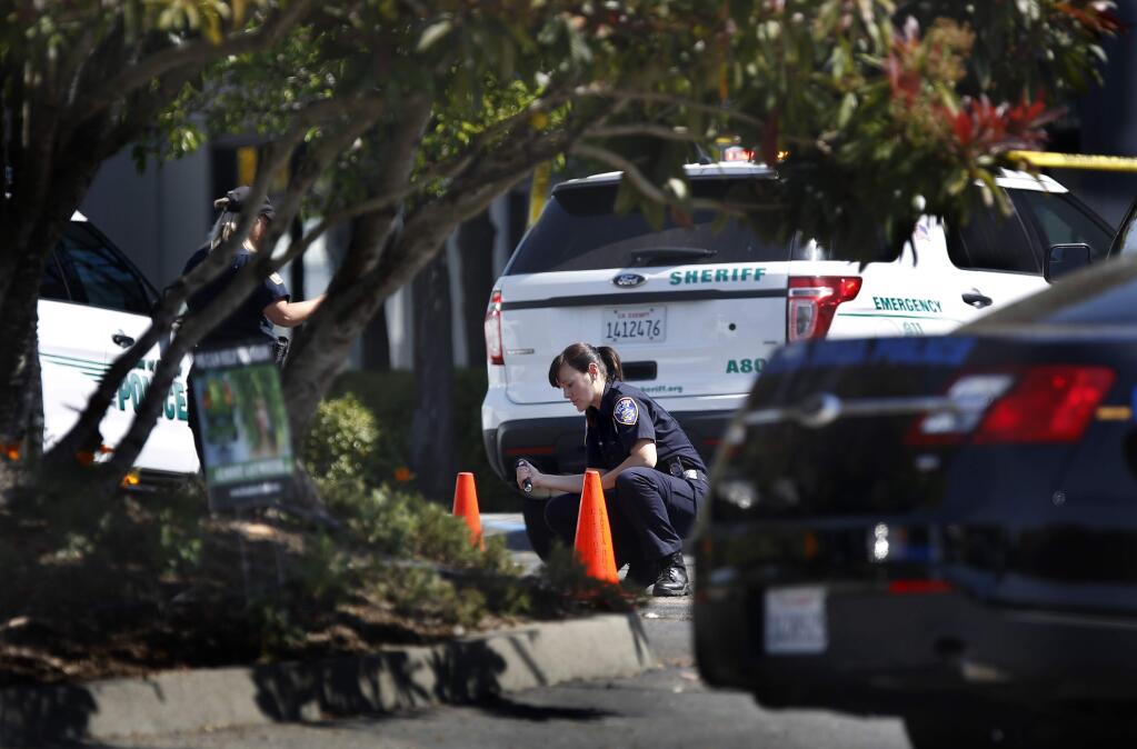 Santa Rosa police field evidence technicians investigate the scene of a Sonoma County sheriff-involved shooting in the parking lot of 2661 Old Gravenstein Highway in Sebastopol, on Thursday, April 23, 2015. (BETH SCHLANKER/ The Press Democrat)