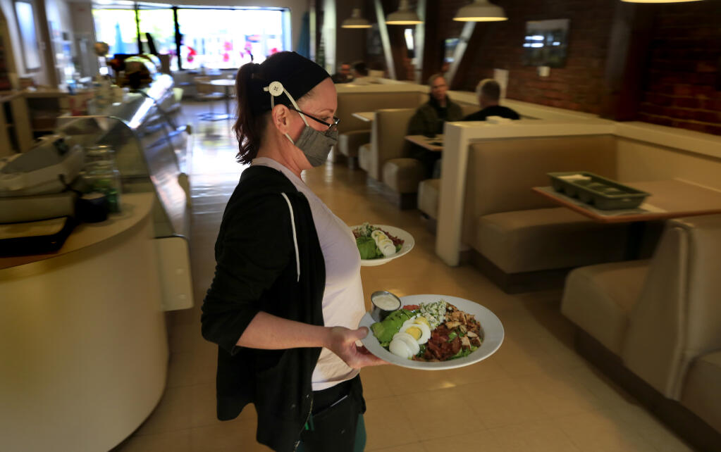 Callie Dilbeck, who has worked at Mac's Deli and Cafe for 20 years, serves up lunch, Wednesday, April 7, 2021 in Santa Rosa.  (Kent Porter / The Press Democrat) 2021