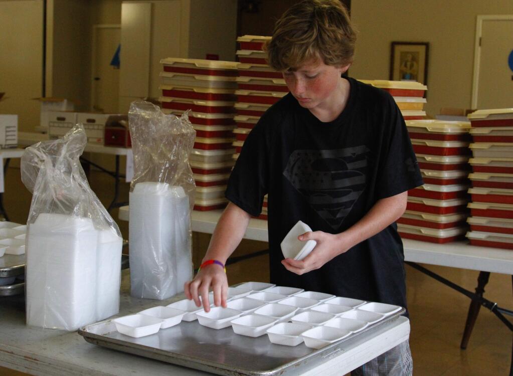 Bill Hoban/Index-TribuneDillon Kiernan, 11, was getting a tray full of cups ready for the Thursday deliveries of Meals on Wheels.