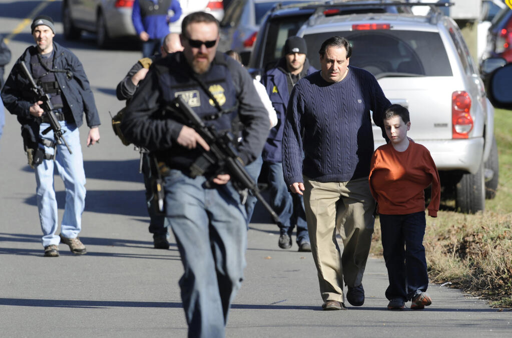 FILE- In this Dec. 14, 2012, file photo, parents leave a staging area after being reunited with their children following a shooting at the Sandy Hook Elementary School in Newtown, Conn. Once again, multiple people were killed in a shooting at an elementary school, this time in Uvalde, Texas, Tuesday, May 24, 2022. (AP Photo/Jessica Hill, File)