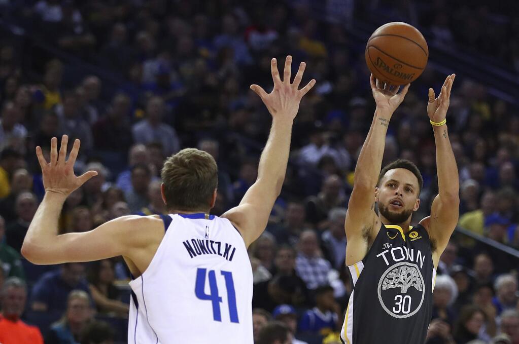 The Golden State Warriors' Stephen Curry shoots over the Dallas Mavericks' Dirk Nowitzki during the second half Thursday, Feb. 8, 2018, in Oakland. (AP Photo/Ben Margot)