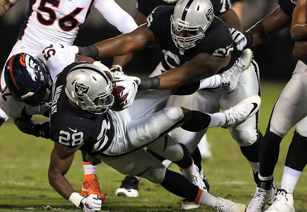 Latavius Murray is brought down by Corey Nelson of the Broncos, Sunday Nov. 6, 2016 in Oakland. (Kent Porter / The Press Democrat) 2016