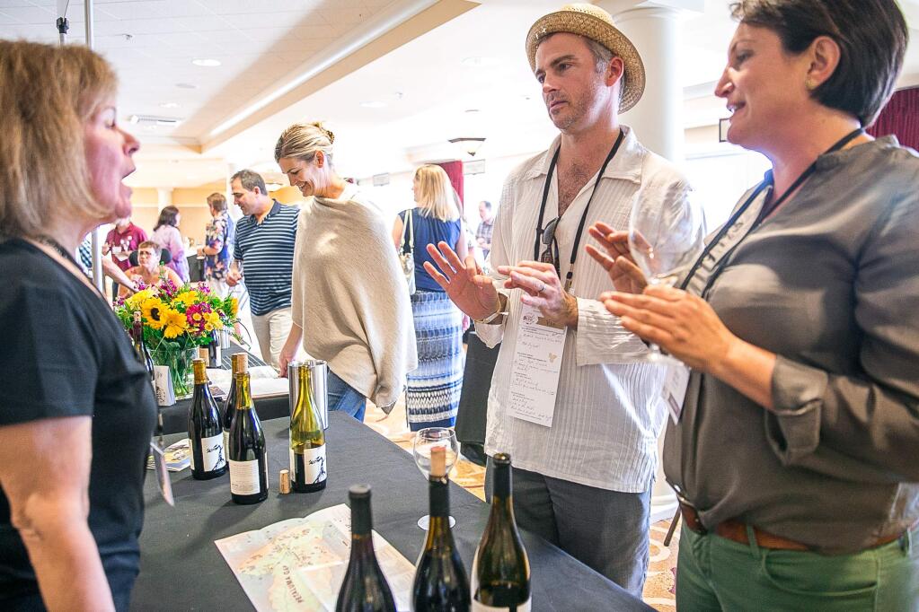 Damien Wilson, Hamel Family Chair of Wine Business Education at the Wine Spectator Institute with SSU, chats with Ana Keller, of Keller Estate Winery, and Joan Griffin, pouring for Griffin's Lair at Petaluma Gap's inaugural WIND to WINE Festival at the Sheraton Petaluma on Saturday, August 8, 2015. (RACHEL SIMPSON/FOR THE ARGUS-COURIER)
