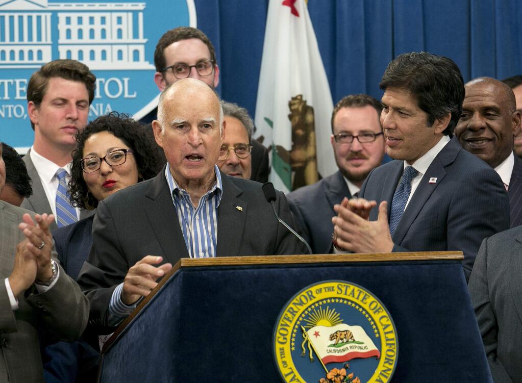Gov. Jerry Brown, flanked by Democratic and Republican lawmakers, discusses legislative approval of cap-and-trade legislation this week. (RICH PEDRONCELLI / Associated Press)