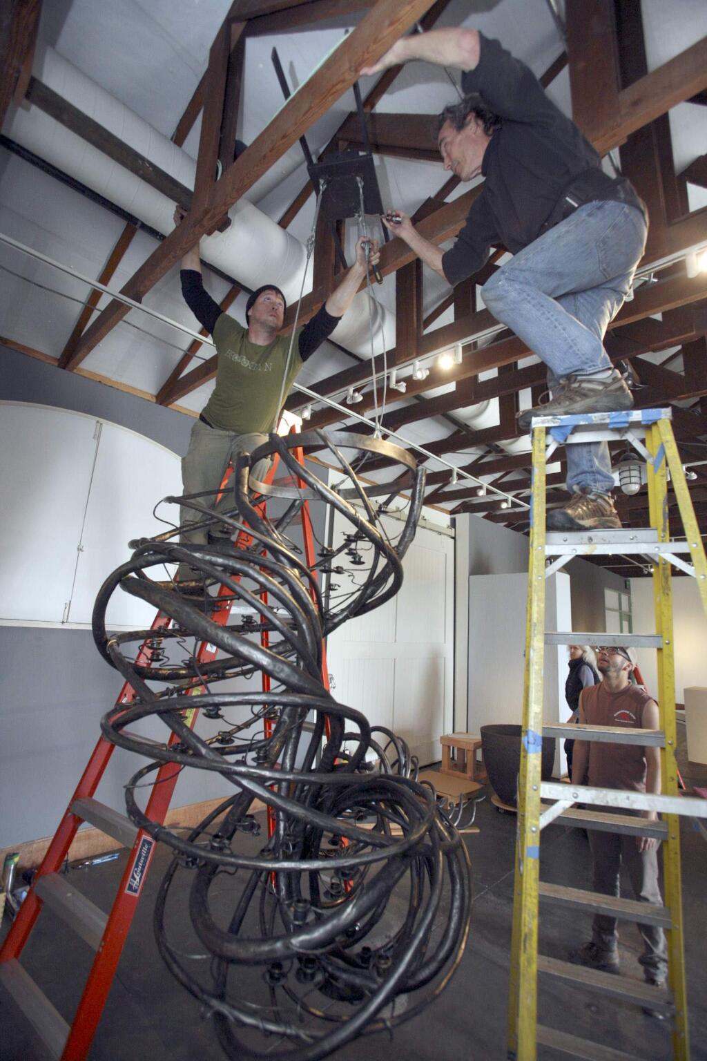 Blacksmith/Artist Daniel Hopper, left, and Museum Installer Nick Krijdt work at hanging Hopper's sculpture The Tornado at the Petaluma Art Center as part of an exhibit that is opening March 19th featuring metal works on Monday, March 14, 2016. (SCOTT MANCHESTER/ARGUS-COURIER STAFF)