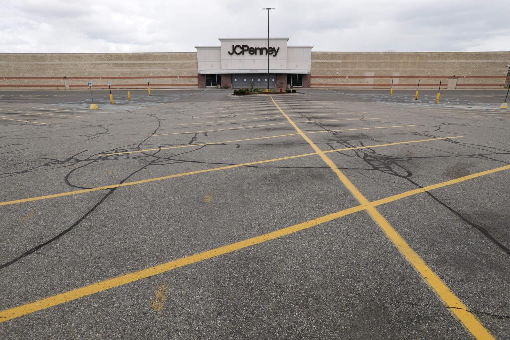 FILE - This May 8, 2020 file photo shows an empty parking lot at a JC Penney store in Roseville, Mich. U.S. retail sales tumbled 16.4% from March to April as business shutdowns caused by the coronavirus kept shoppers away, threatened stores across the country and weighed down a sinking economy. (AP Photo/Paul Sancya, File)