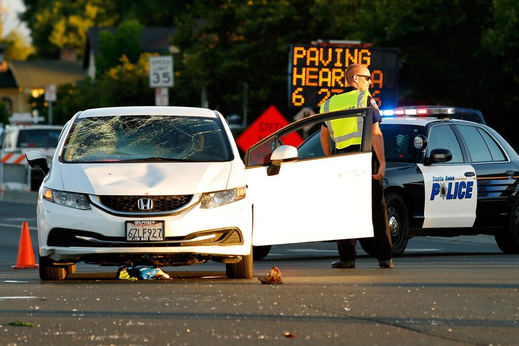 Santa Rosa police officers investigate the scene of an accident where a car struck a bicycle rider at the intersection of Stony Point and Sebastopol roads in Santa Rosa Tuesday, June 27, 2017. (ALVIN JORNADA/ PD)
