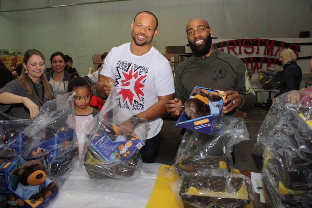 Christina Brunette Hoffemeger, far left, Oakland Raiders alumnus Lorenzon Alexander and DeAngelo Hall, a 13-year veteran of the Washington Redskins, joined hundreds of volunteers packing 3,500 Super Baskets of Hope to be distributed to Northern California hospitalized kids. (Gary Quackenbush / North Bay Business Journal)