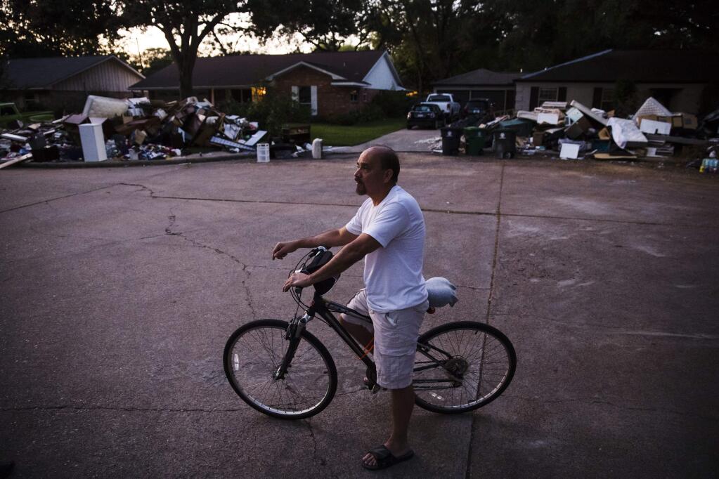 In this Wednesday, Sept. 6, 2017, photo, Mike Martinez speaks with The Associated Press in the aftermath of Hurricane Harvey in Houston. Harvey's record-setting rains now have the potential to set records for the amount of debris one storm can produce. (AP Photo/Matt Rourke)