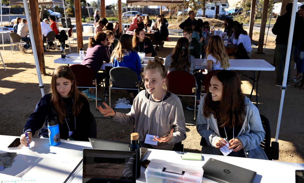 Analy High School students, from left, Lyla Hanauer, Stella Finley and Lena Yakzan discuss their objective, Thursday, Oct. 6, 2022 during the kickoff of the Environmental  Justice Coalition at Andy Lopez Unity Park in Santa Rosa.  (Kent Porter / The Press Democrat) 2022