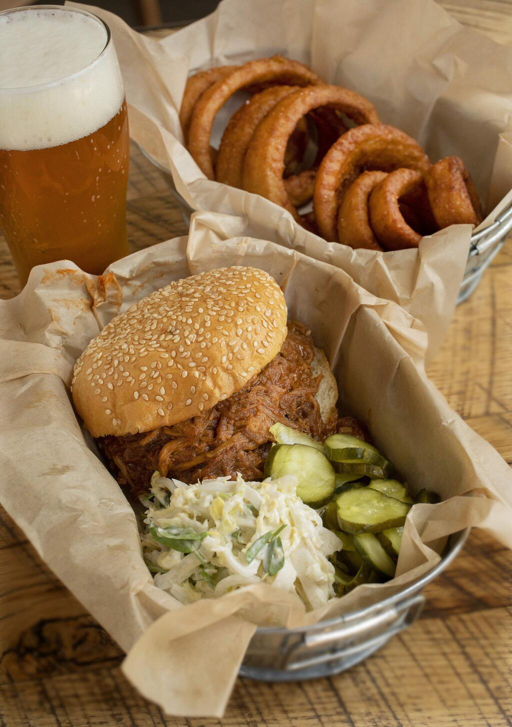 Berkwood Farms Pulled Pork Shoulder Sandwich with slaw and pickles with a side of Beer Battered Onion Rings from Roadhouse 29 at the Freemark Abbey Winery in St. Helena. (photo by John Burgess/The Press Democrat)