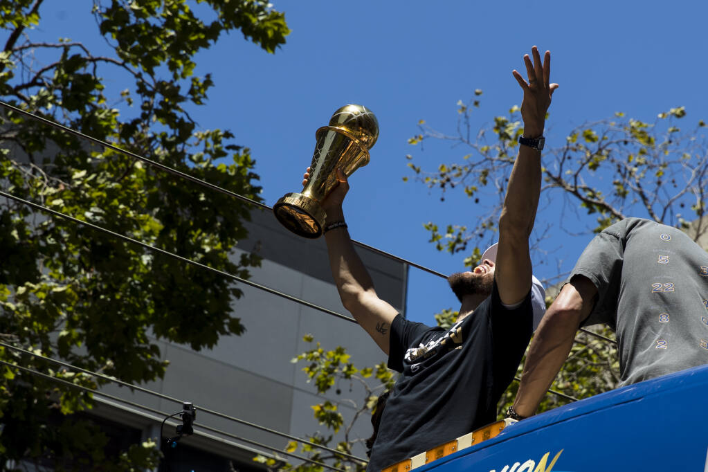 Golden State Warriors' Stephen Curry reacts as he holds the MVP trophy during the NBA Championship parade in San Francisco, Monday, June 20, 2022, in San Francisco. (AP Photo/John Hefti)