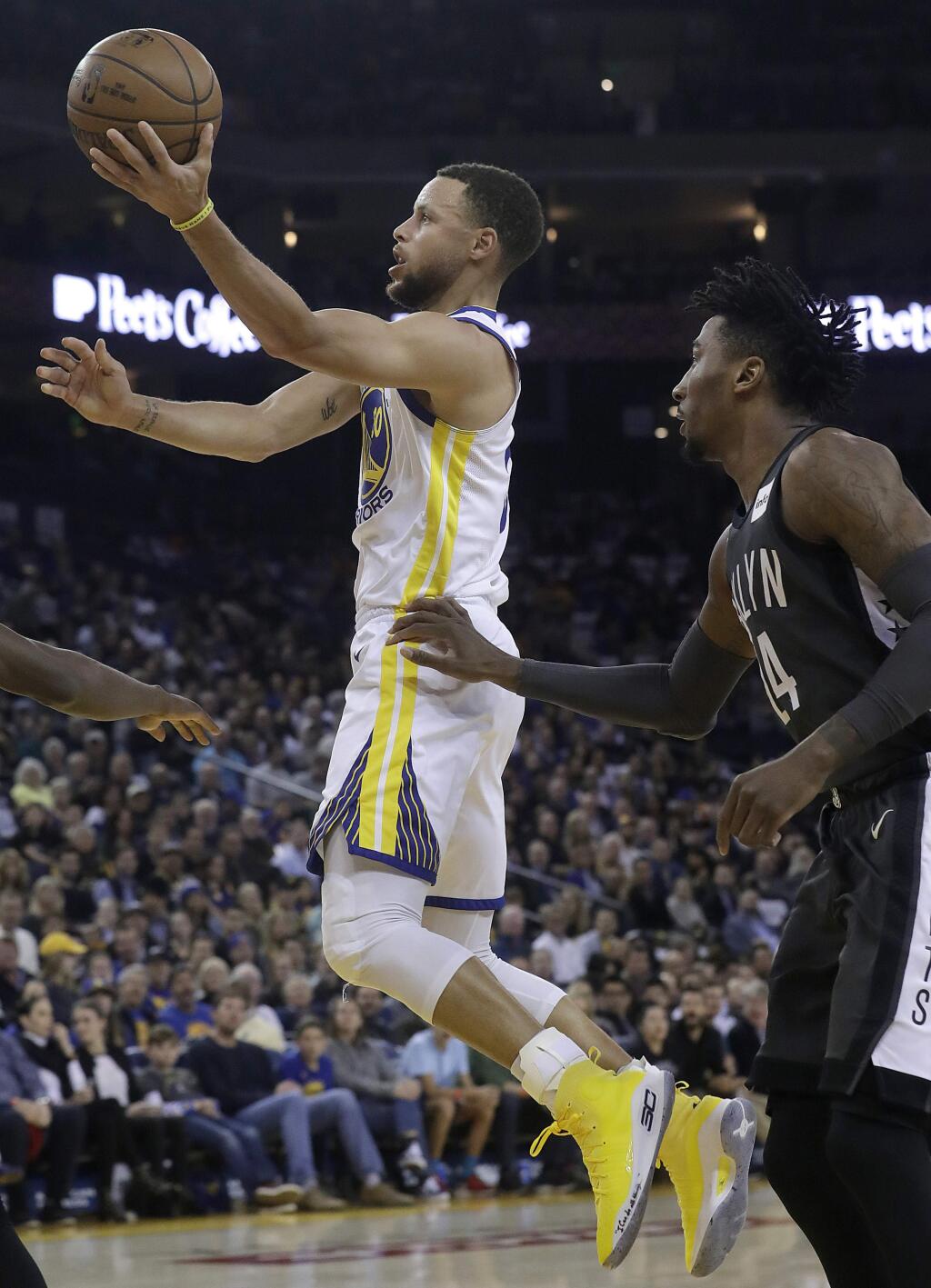 Golden State Warriors guard Stephen Curry, left, shoots in front of Brooklyn Nets forward Rondae Hollis-Jefferson during the first half of an NBA basketball game in Oakland, Calif., Tuesday, March 6, 2018. (AP Photo/Jeff Chiu)