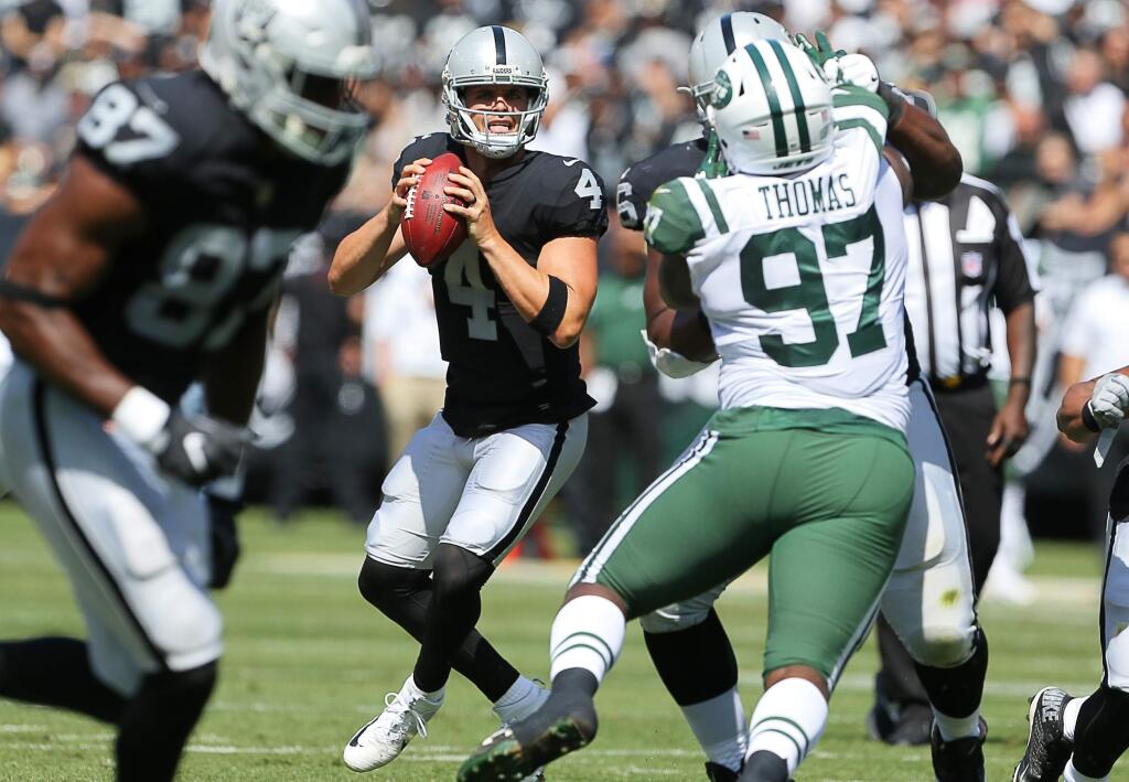 Oakland Raiders quarterback Derek Carr looks for an open receiver against the New York Jets, in Oakland on Sunday, Sept. 17, 2017. (Christopher Chung / The Press Democrat)